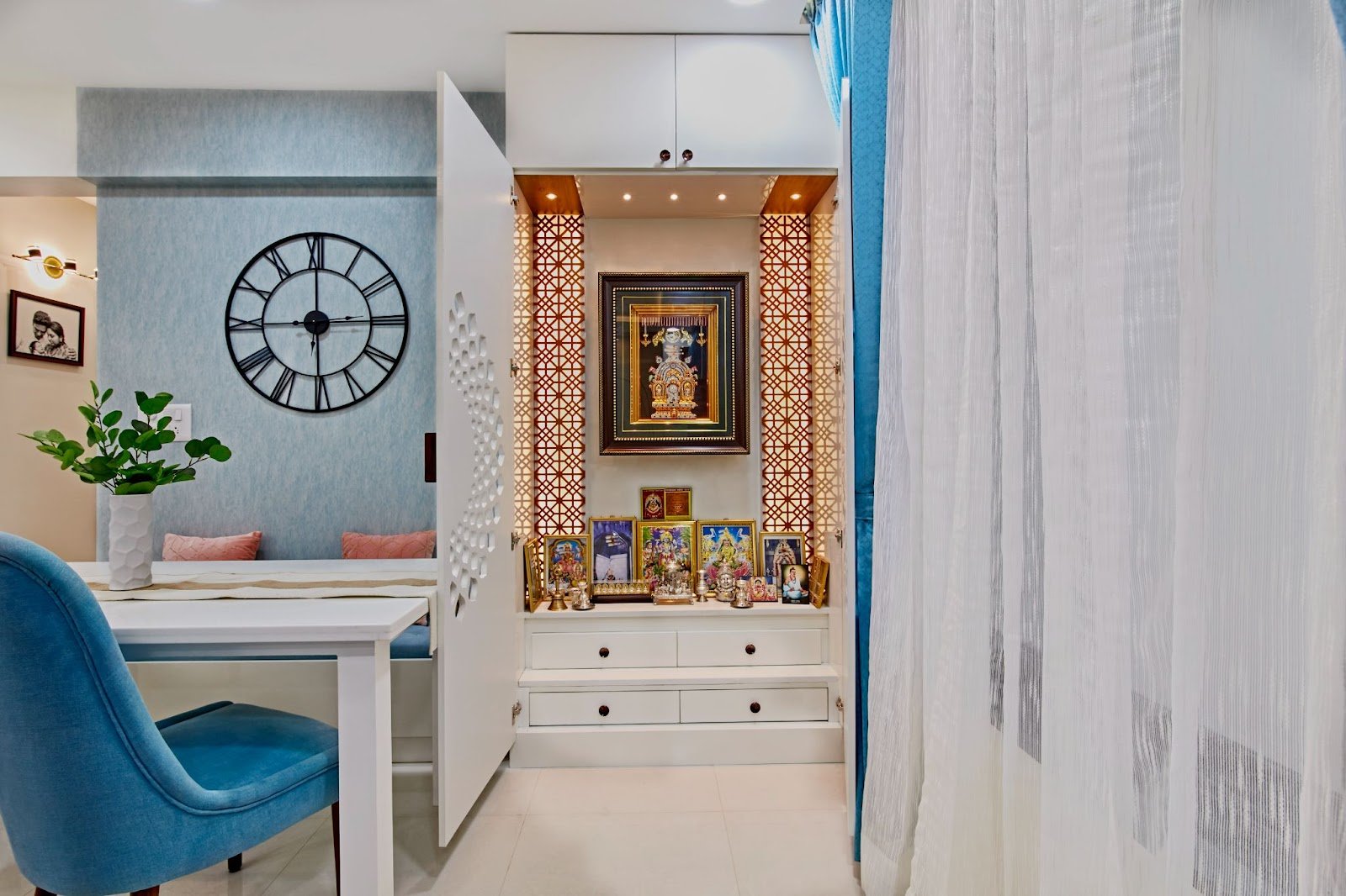 A modern pooja room design with idol pictures by Interiosplash Interior Design Company