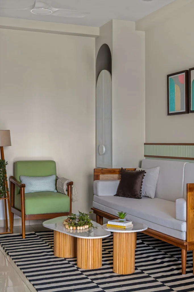Modern and Minimalistic living room with customized wooden sofa, wooden armchair featuring seats with soft green colour, marble-topped statement coffee table placed on the black and white stripes rug, and floor lamp furnished with an indoor plant, which adds cosiness to this contemporary interior design